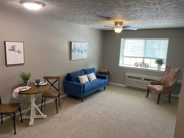 Apartment living room with couch and table with chairs at a senior living community in Omaha, Nebraska.