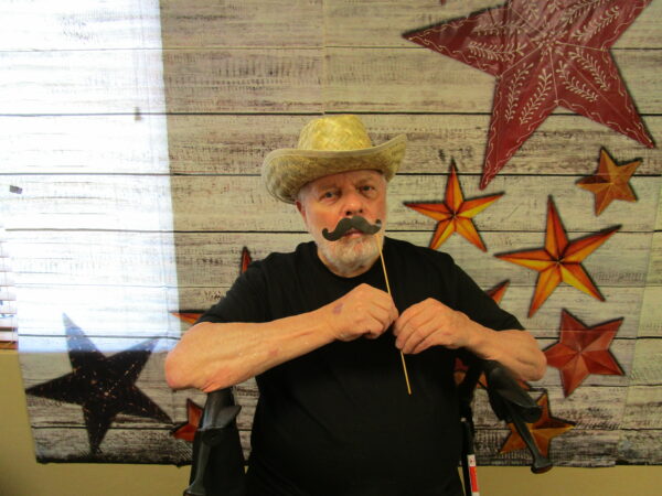 senior man poses in a photo booth at brookview meadows