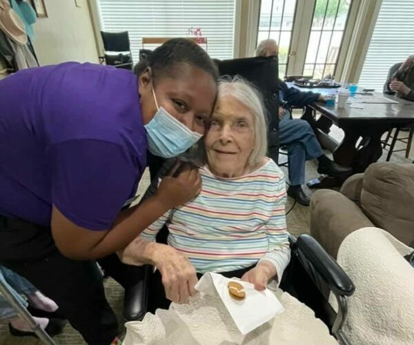 woman caregiver gives a senior woman a hug