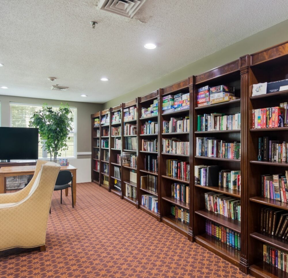 large bookshelves, a TV and a chair in the on-site library