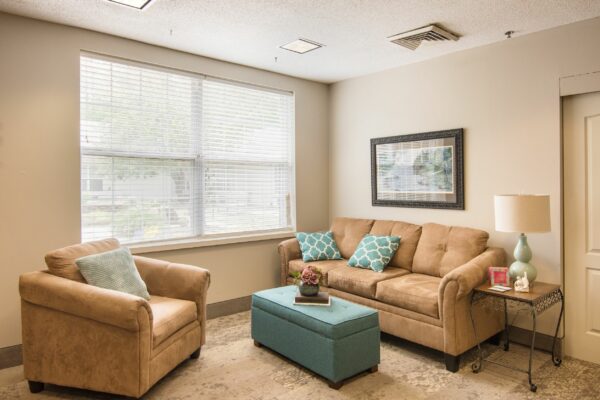 senior apartment living room with couch and chair near a large window