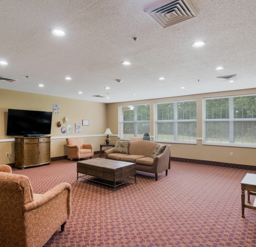 TV lounge with couches, chairs and a piano