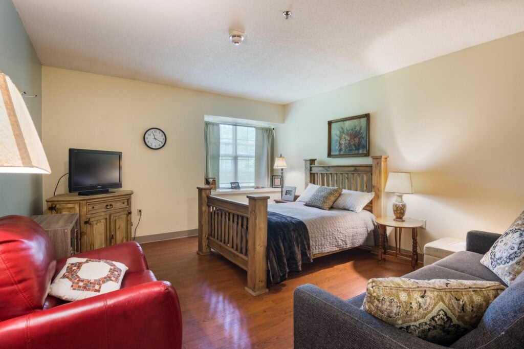 bedroom with TV, couch and chair