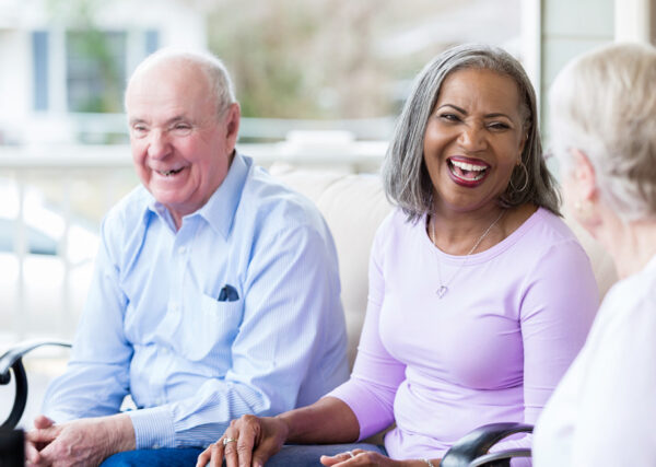 Senior adults laughing together at a Sonida Senior Living community.