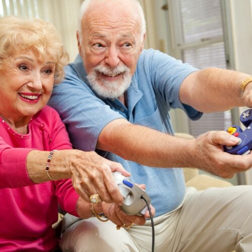 Senior couple having fun playing video games