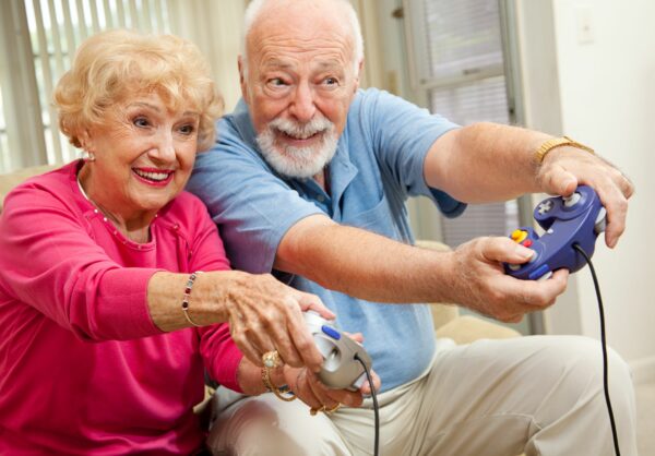 Senior couple having fun playing video games