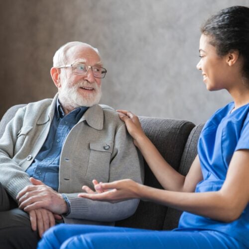 Young african nurse helping senior old elderly man grandfather