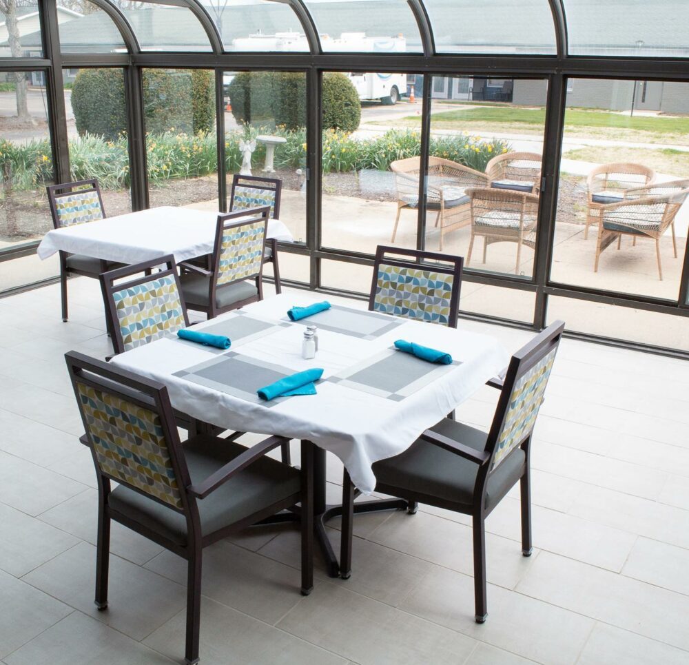 dining room tables and chairs with a wall full of windows