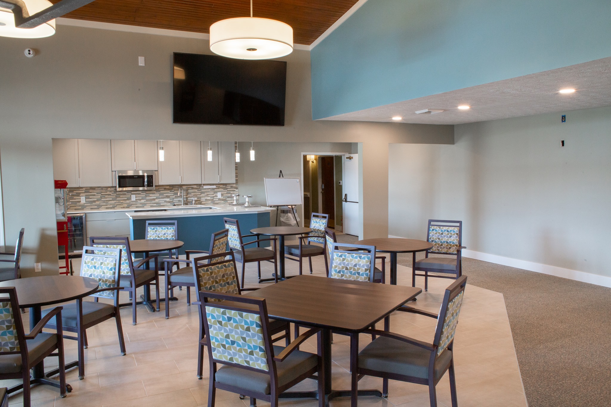 Dining room space with a bar and multiple tables and chairs at The Oaks at Brownsburg