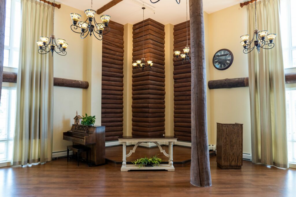 community room with tall ceilings, a grand piano and chandeliers