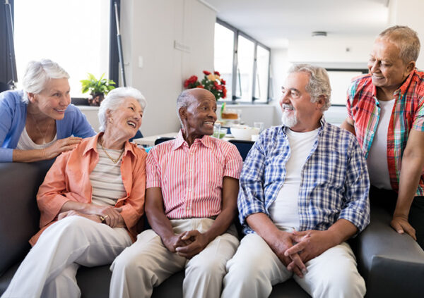 five seniors on a couch looking at each other and laughing