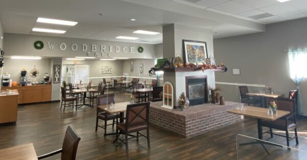 dining room space with multiple tables and chairs and a central fireplace