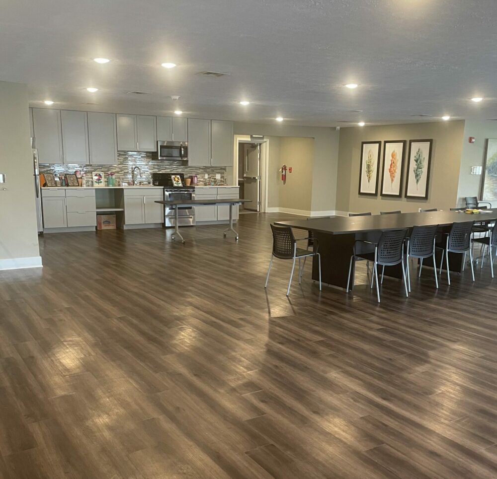 the oaks at brownsburg community room includes a kitchen and large table with chairs
