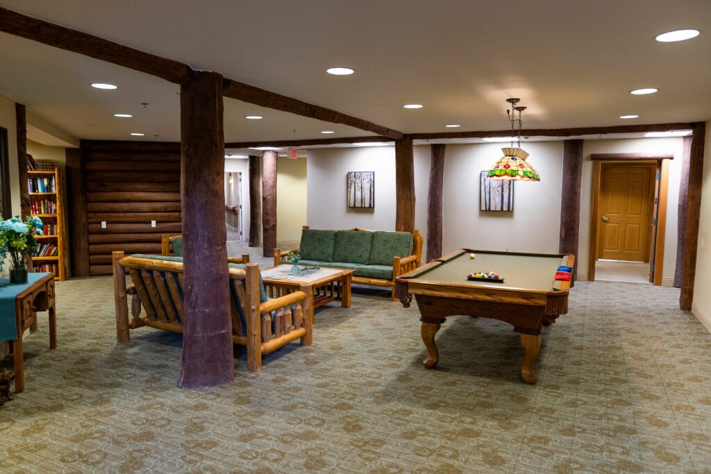 Billiards table with seating and book shelf