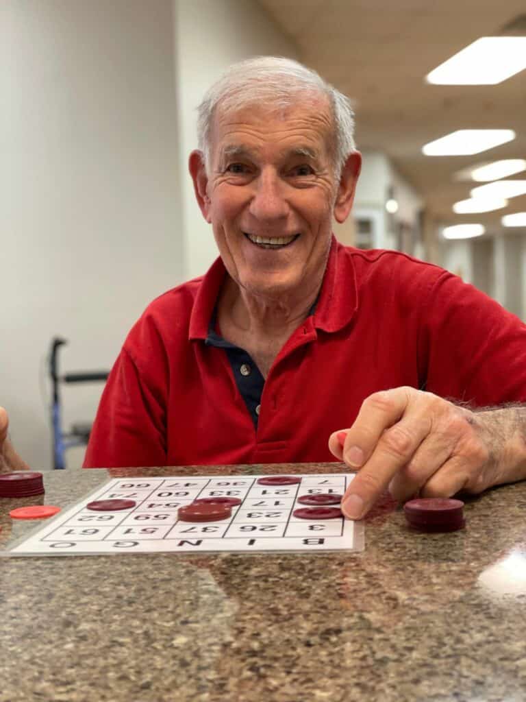senior man smiles while playing bingo
