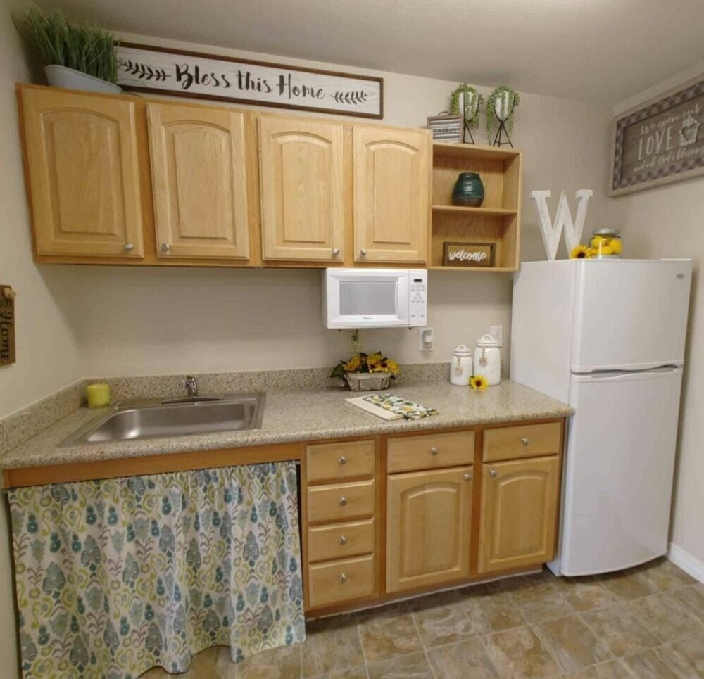 kitchen with a fridge, sink, microwave and storage