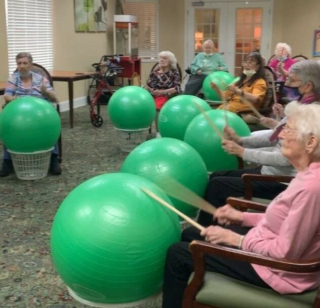group of senior women do a drumming exercise together