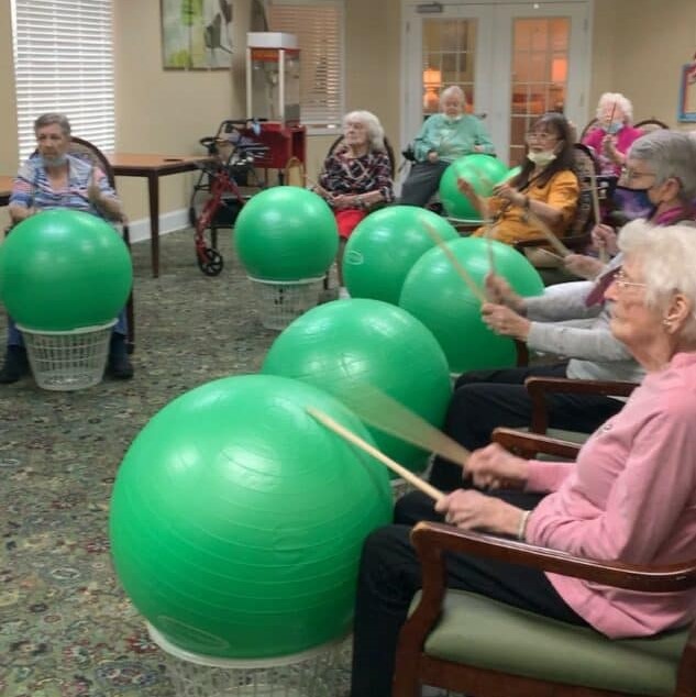 group of senior women do a drumming exercise together
