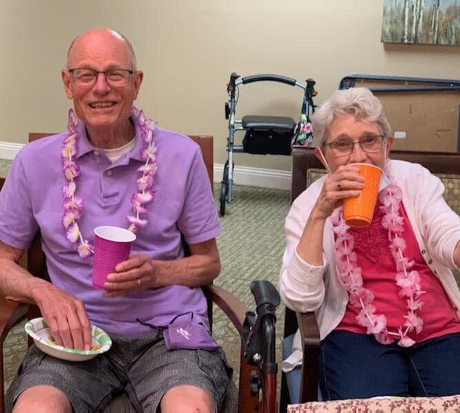senior man and senior woman at a Hawaiian themed party