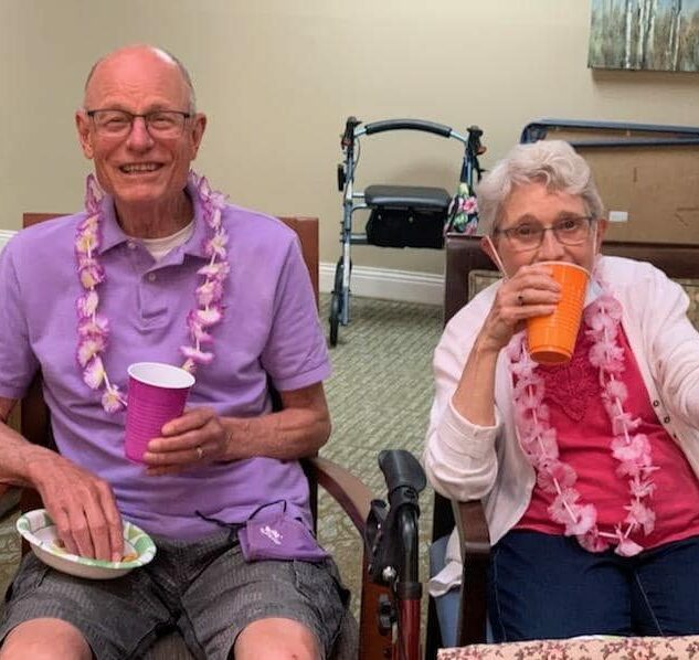 senior man and senior woman at a Hawaiian themed party