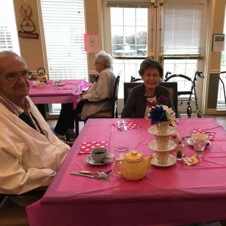 two seniors smile at the camera during a themed dinner party