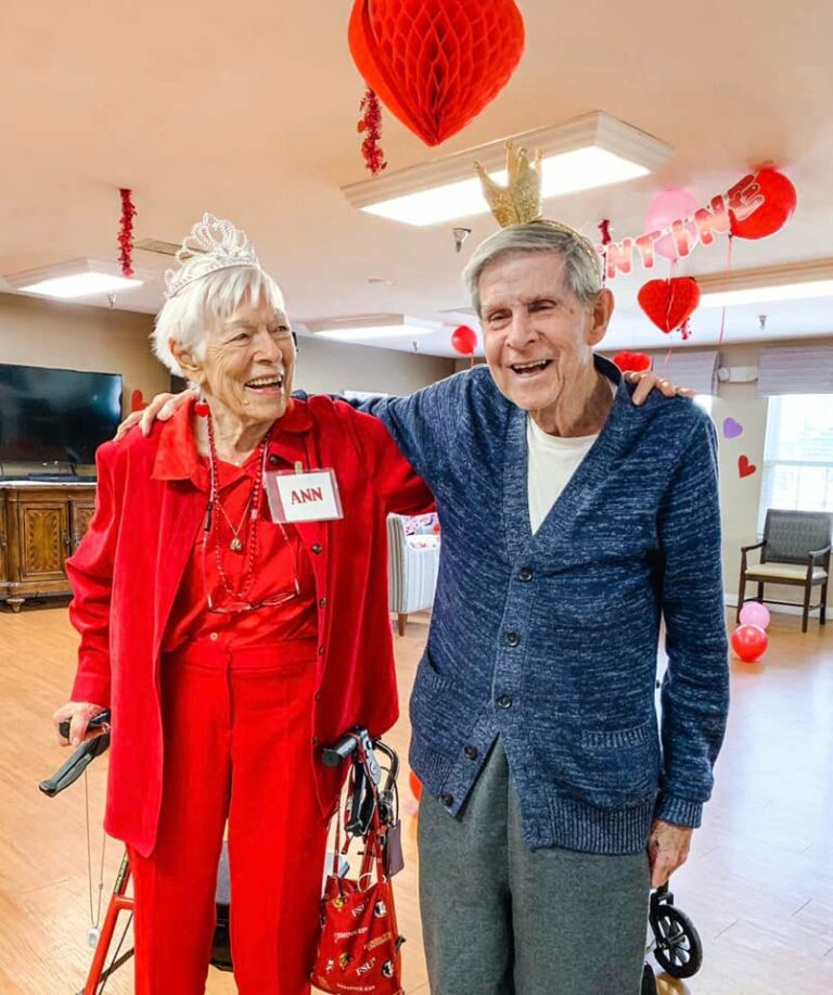 senior man and senior woman smile at each other during a valentines day party