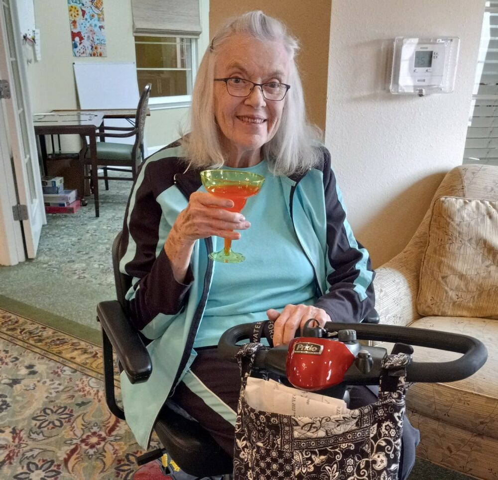 senior woman smiles and holds her drink