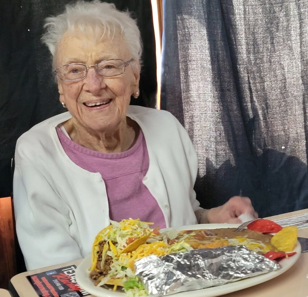senior woman smiles while eating a meal at a Mexican restaurant