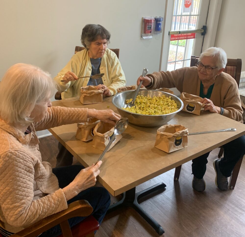 three senior women make popcorn together