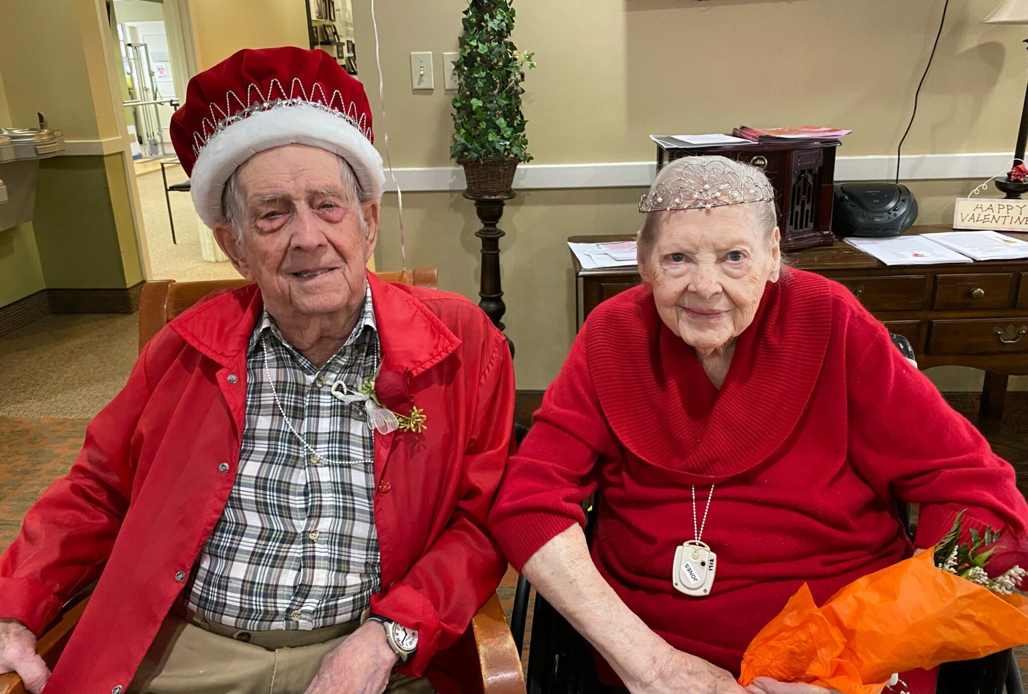 A senior man and senior woman pose together as king and queen of their senior living community