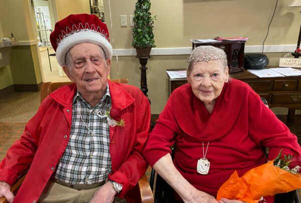 senior man and senior woman pose together as king and queen