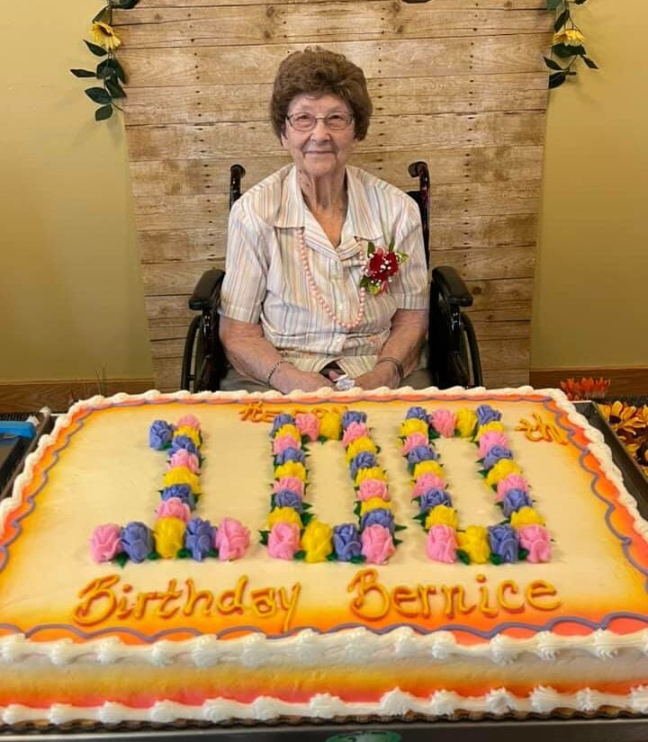 senior woman smiles with her birthday cake