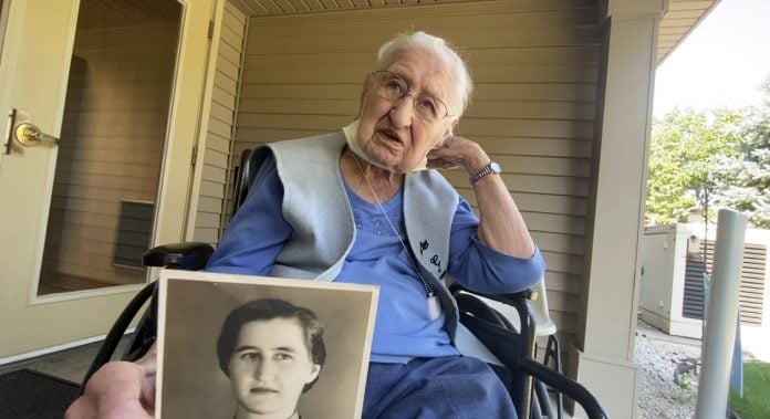senior woman talks about her past while holding an old image of herself