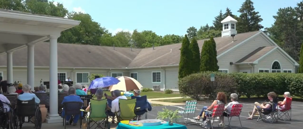 seniors sit outside during a church service