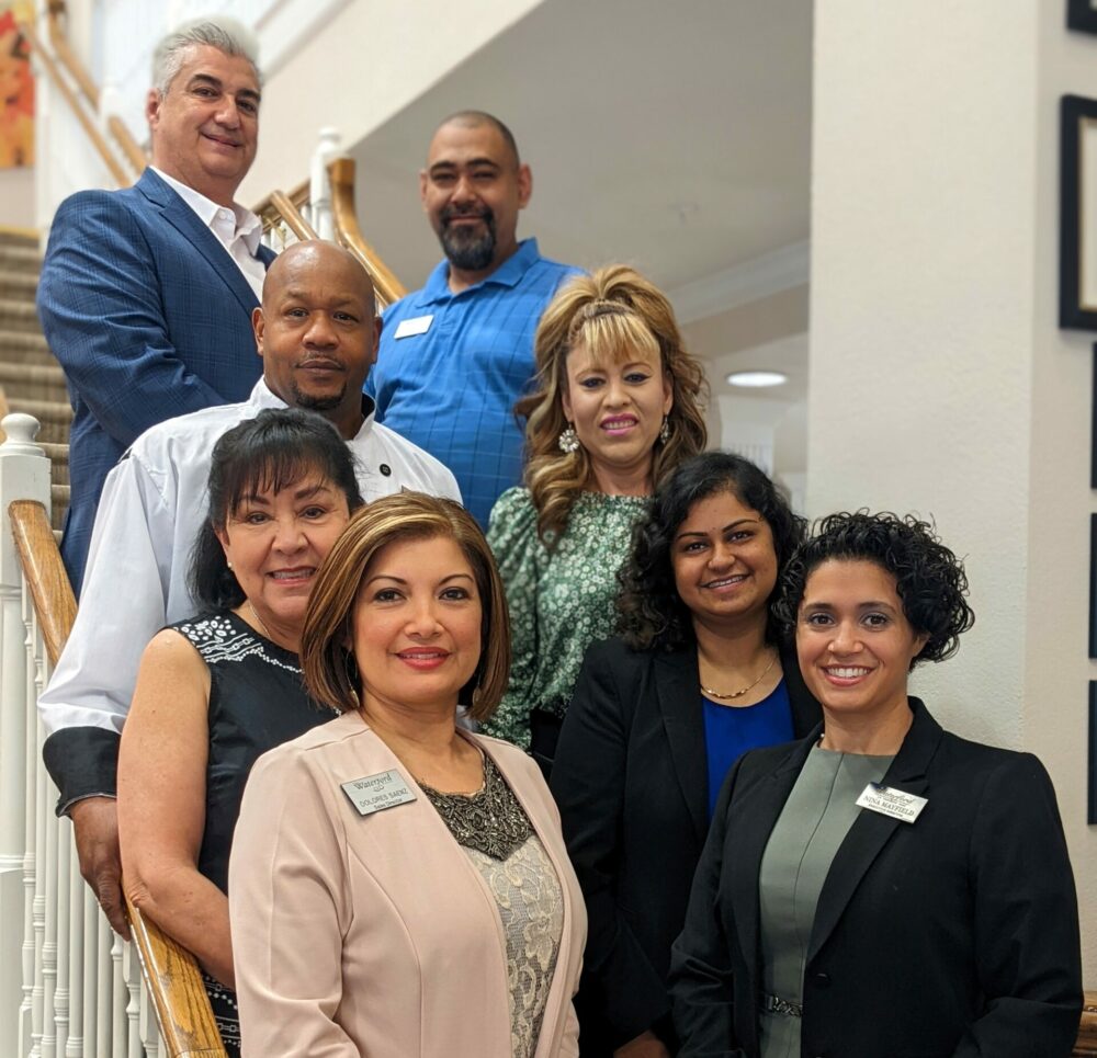 eight employees pose together on staircase