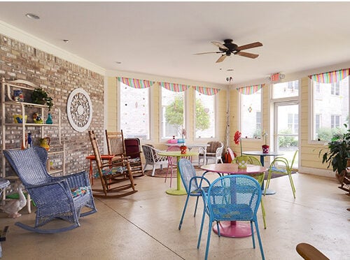 Greenbriar Village senior living community sunroom with seating and tables for playing games.