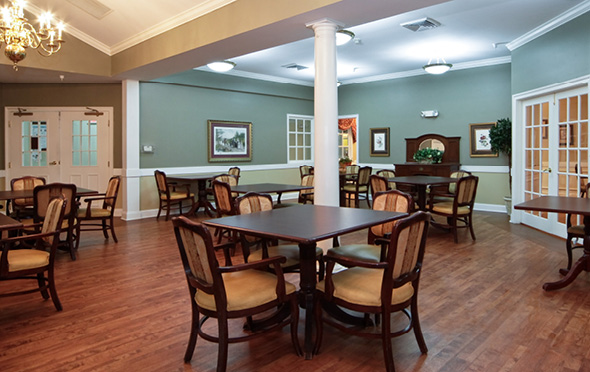 Senior living dining room with many tables.