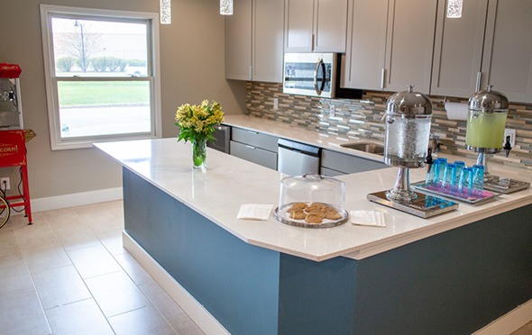 Public kitchen area at senior living community with microwave and dishwasher.
