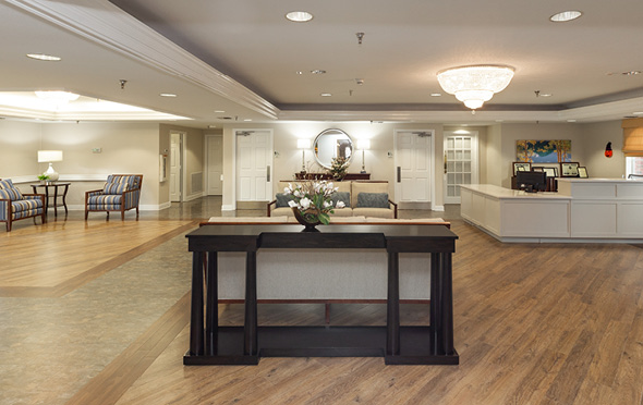 Expansive lounge with sitting area at senior living community.