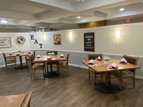 dining room space with multiple tables and chairs for memory care residents