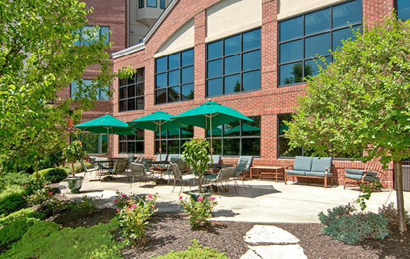 Outdoor courtyard with covered tables at a senior living community
