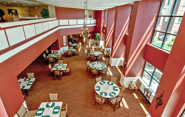 Two-story dining room with ample seating at a senior living community.