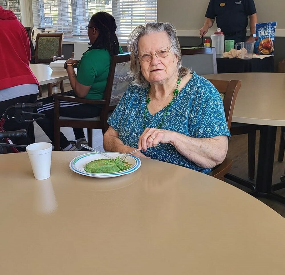 senior woman eats green pancakes during st. patricks day party