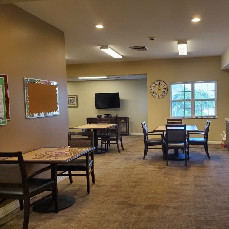 Activity room with tables, chairs, TV and countertop at a senior living community in Chardon, Ohio.