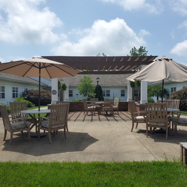 Outdoor courtyard with tables, chairs and garden at a senior living community in Chardon, Ohio.