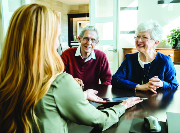 two senior living residents talk with an advisor