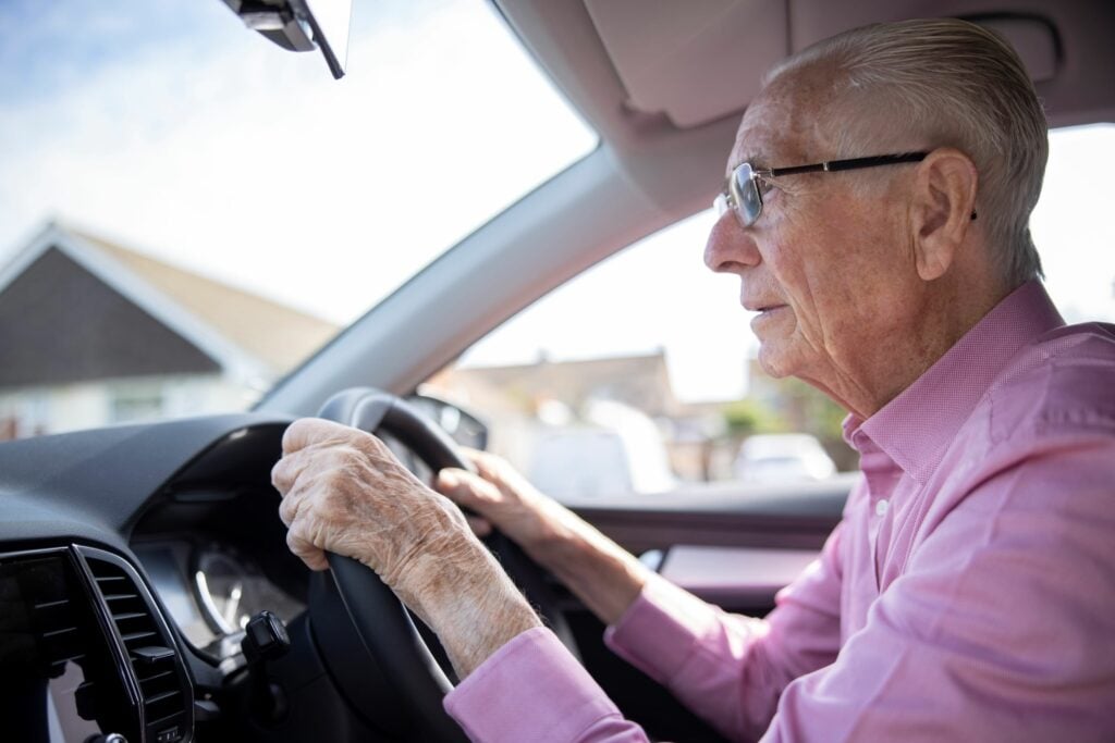 Senior Male Driver Looking Through Car Windscreen