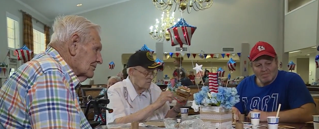 three senior men attend a veterans event at a senior living community