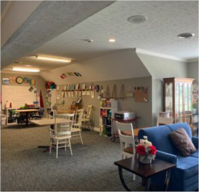 activity room with craft table, blue couch and white board