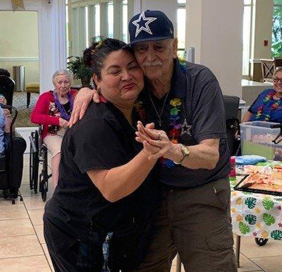 Senior man and caretaker dancing at senior living facility in Corpus Christi, Texas.